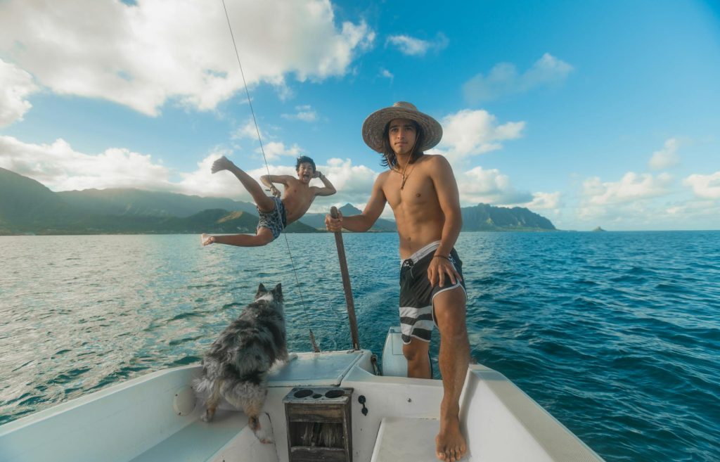 cost of living in hawaii: hawaii boat with guy jumping off